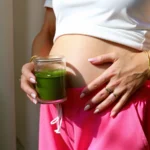 can I drink matcha while pregnant – woman holding matcha tea near baby bump
