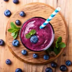 Purple peel weight loss smoothie with blueberries and mint on wooden table