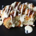 Sourdough cinnamon roll focaccia slice drizzled with cream cheese glaze