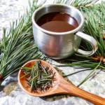 tea from pine needles served in a metal cup with fresh pine sprigs