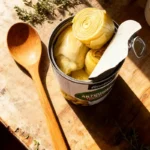 Canned artichoke hearts on rustic counter