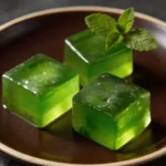 Homemade Green Tea Gelatin Recipe for Weight Loss served as clear green cubes on a dark plate.