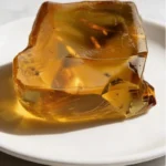 The master Ray Peat Gelatin orange metabolic tonic on a dark marble surface, prepared for thyroid support and cortisol control