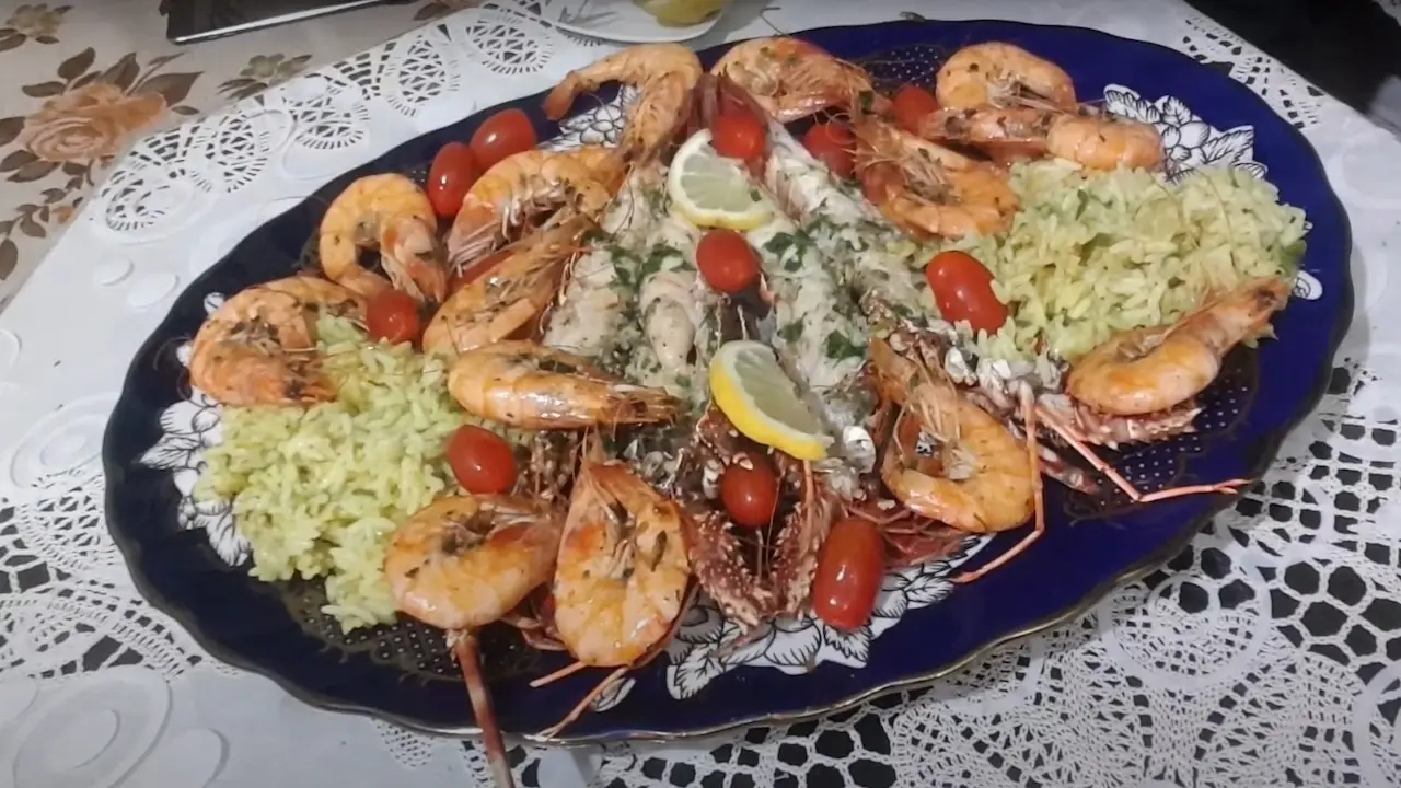 Homemade seafood rice platter with shrimp, lemon, and fresh herbs, prepared by Emily.