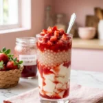 Strawberry taho recipe: tall glass with layered silken tofu, tapioca pearls, and vibrant strawberry syrup topped with fresh diced strawberries.